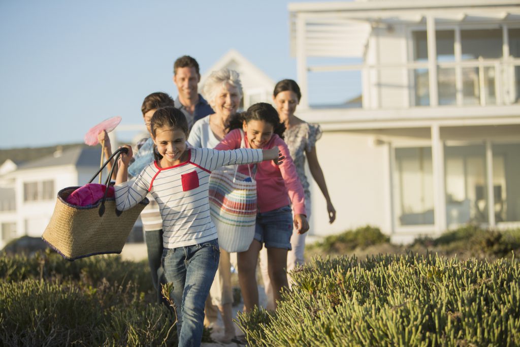 family walking on a path to get to the beach to explore and spend time together.