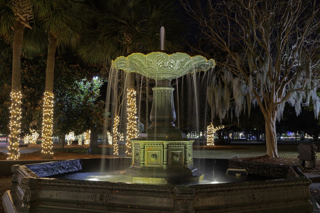 Fountain at Marion Square Park in Charleston, SC. Long exposure, night, holiday decorations on background trees.